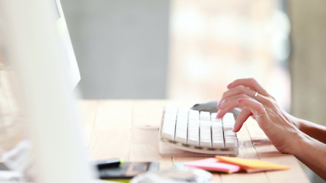 Woman typing on computer at desk