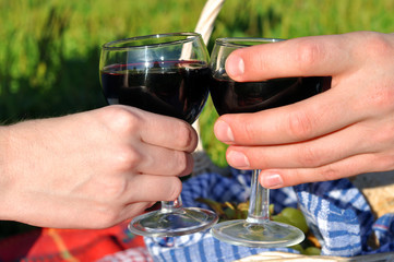 Hands holding glasses of red wine