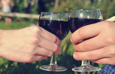 Hands holding glasses of red wine