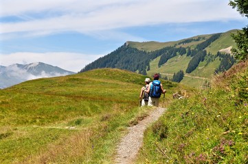 Fototapeta na wymiar Zwei Wanderer auf Wanderweg in den Schweizer Alpen