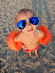 funny girl in sunglasses on summer beach