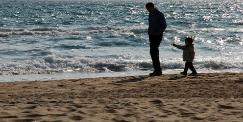 Padre e figlio a passeggio in spiaggia