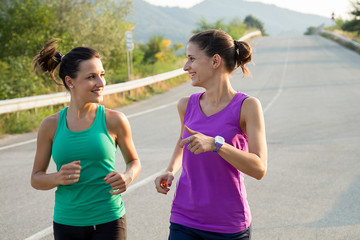 due donne giovani che corrono per strada al tramonto