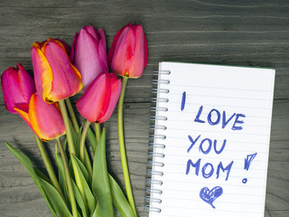 tulip bouquet and notepad with words "I love you mom"