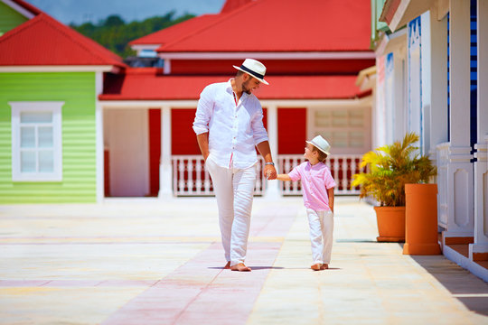 happy father and son walking on caribbean village street