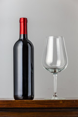 empty wine glass and red wine bottle - table