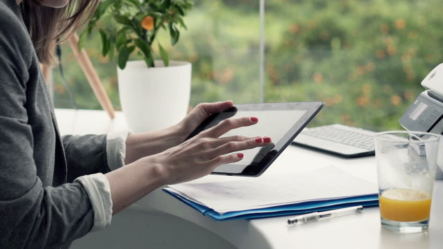 Businesswoman hands using tablet computer sitting in office

