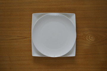 Empty porcelain plate on a wooden table top