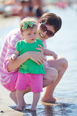 Obraz na płótnie Canvas mom and baby on beach have fun
