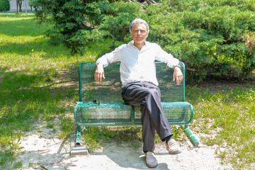 Old reassuring man resting on a bench