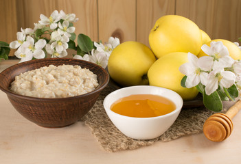 Yellow apples with oatmeal and honey, twig of apple tree