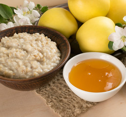 Yellow apples with oatmeal and honey, twig of apple tree