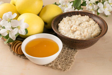Yellow apples with oatmeal and honey, twig of apple tree