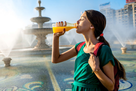 Woman Drinking Juice Near The Fountain