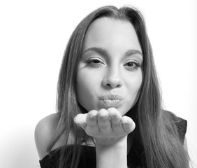 Portrait of a girl teenager gives a kiss. Isolated over white background