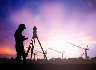 silhouette survey engineer working  in a building site over Blur - obrazy, fototapety, plakaty