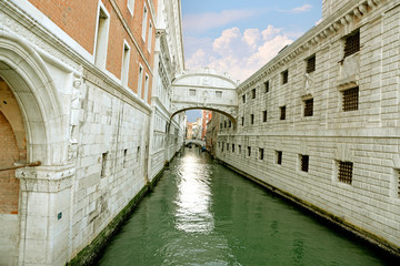Fototapeta premium Gondola on small canal passing towards famous Bridge of Sighs (Ponte dei Sospiri) in Venice, Italy.