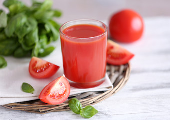 Tomato juice and fresh tomatoes on wooden table close-up