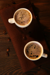 Cups of coffee on napkin on table close up