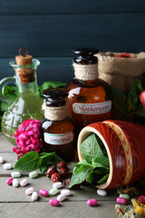 Herbs, berries, flowers and pills on color  wooden table background