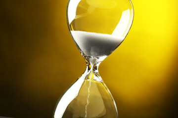 Hourglass on dark yellow background