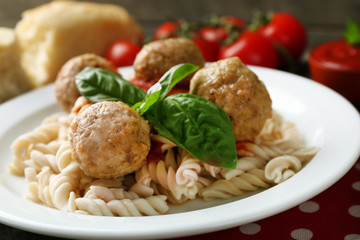 Pasta with meatballs on plate, on wooden  table background