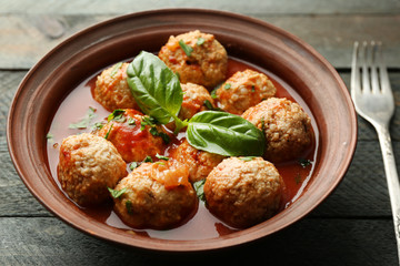 Meat balls with tomato sauce, on wooden background
