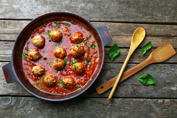Pan with meat balls in tomato sauce, on wooden background