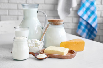 Dairy products on wooden table, on brick wall background