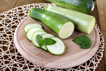Fresh zucchini with squash and basil on table close up