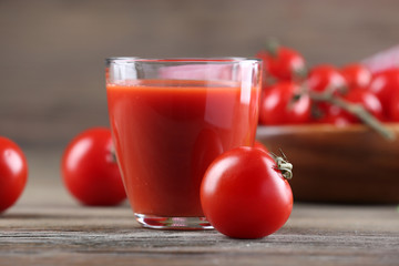 Glass of tomato juice with vegetables on wooden table close up