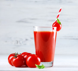 Glass of tomato juice with vegetables on wooden background