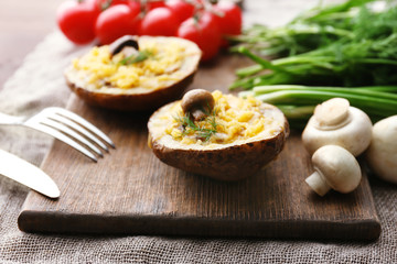 Baked potatoes with cheese and mushrooms on table close up