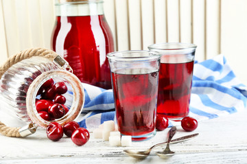 Sweet homemade cherry compote on table, on light background