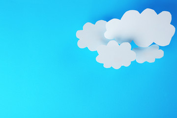 White paper clouds on blue background. Cloud computing concept.