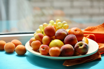 Heap of fresh fruits on windowsill