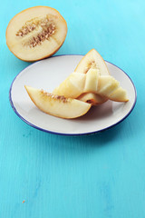 Slices of ripe melon on wooden table close up