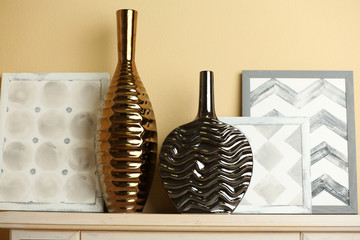 Modern vases with decor on fireplace in room