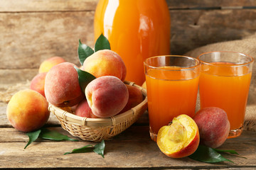 Ripe peaches and juice on wooden background