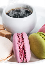Cup of coffee and macaroons on white background