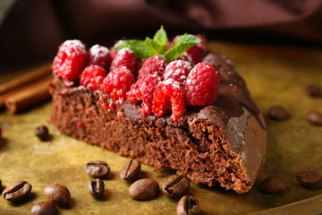 Piece of cake with Chocolate Glaze and raspberries on tray, close-up