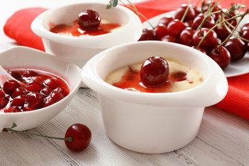 Tasty pudding with cherries on table close up