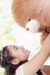 Beautiful girl play with teddy bear outside