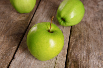 Ripe green apples on wooden table close up
