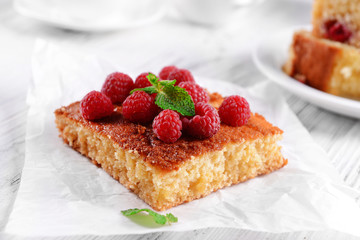 Fresh pie with raspberry on parchment on wooden table, closeup