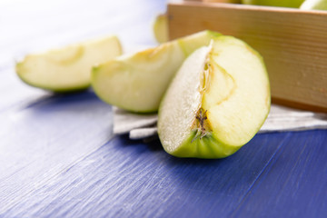 Pieces of green apple on wooden table, closeup
