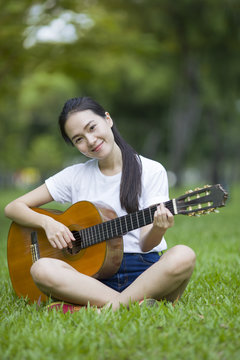 Young attractive woman playing acoustic guitar
