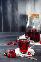 Sweet homemade cherry juice on table, on color wooden background