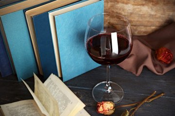 Beautiful composition with glass of wine with old books on table close up