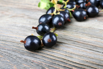 Pile of black currants on wooden table, closeup